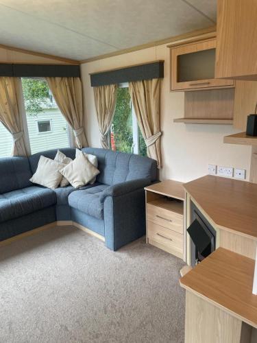 a living room with a blue couch in a caravan at 48 Rosewood Isle of Wight in Porchfield