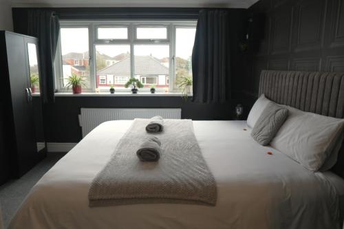 レイランドにあるDetached Homestay - Super, King & Double Rooms - Leyland, Preston, Chorley, Lancashireのベッドとタオル2枚のある寝室