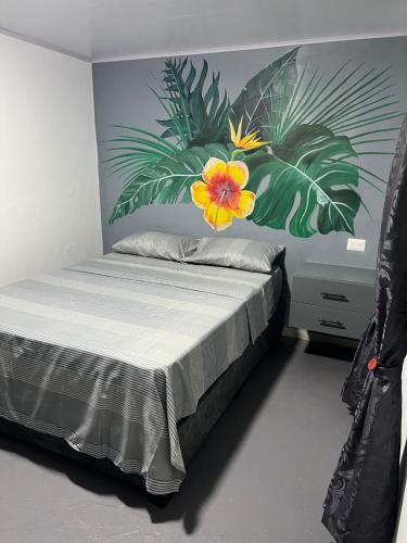 a bedroom with a bed with a flower on the wall at Alojamiento Rural Cafetero, Andinapolis, Trujillo 