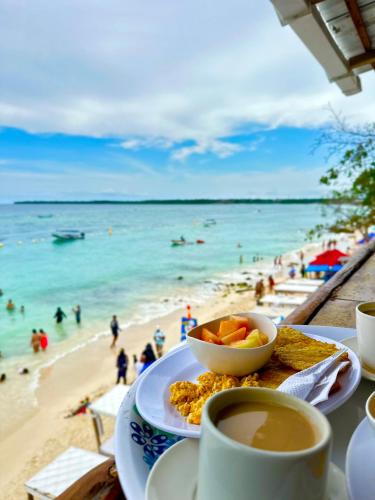 stół z talerzem jedzenia z widokiem na plażę w obiekcie PARAIiSO FRENTE AL MAR w mieście Playa Blanca
