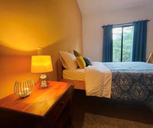 Un dormitorio con una cama y una mesa con una lámpara. en Cozy and Peaceful Beach Apartment, en Playa Grande