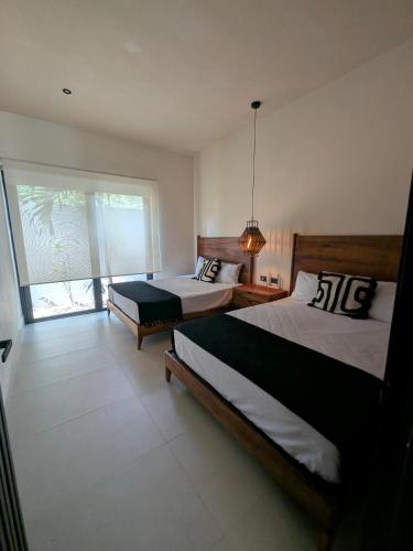 a bedroom with two beds and a large window at Luxury 4 Bedroom Villa with Private Pool in Tulum