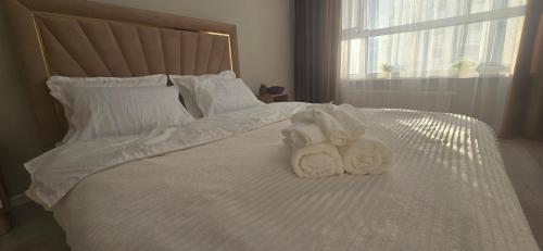 アスタナにあるApartaments Astanaの白いベッドの上にタオル2枚