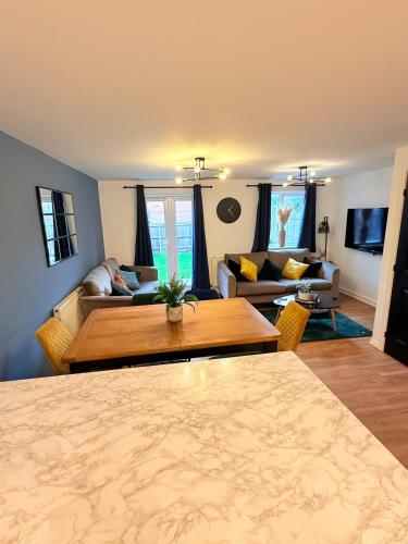 a living room with a table and a couch at Stylish Townhouse in Rugby, sleeps up to 9! in Rugby