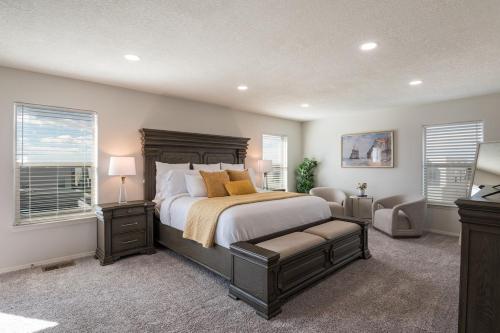 a bedroom with a bed and a chair and windows at Luxury 5 BR Oasis Movie Room Fenced Yard in Albuquerque