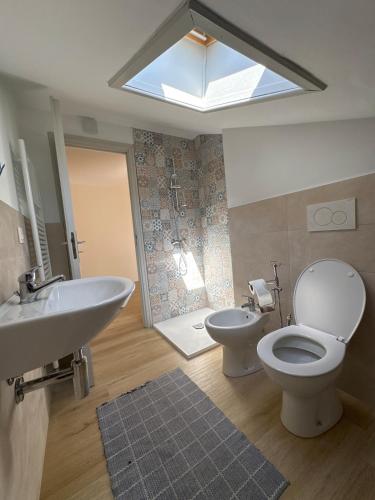 a bathroom with a toilet and a sink and a window at La casa i due cedri in Cuneo
