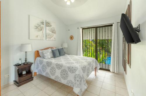 una camera da letto con un letto, una tv e una finestra di Pura Armonia Condo With Outdoor Patio a Coco