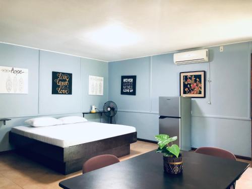 a bedroom with a bed and a table and chairs at Skipper Joes Resort in Dauis