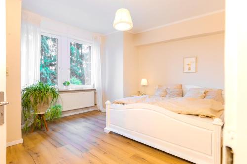 a white bedroom with a bed and a window at Ferienwohnung Villa Waldeck, Alleinlage - Eigene Sonnenterrasse - Küche in Bad Kissingen