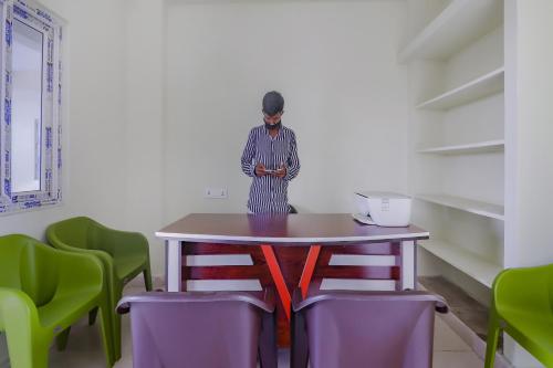 a person standing next to a table with chairs at Hotel O Sri Residency in Hyderabad