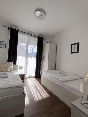 ein Schlafzimmer mit zwei Betten und einem großen Fenster in der Unterkunft Pinocchio in Bihać