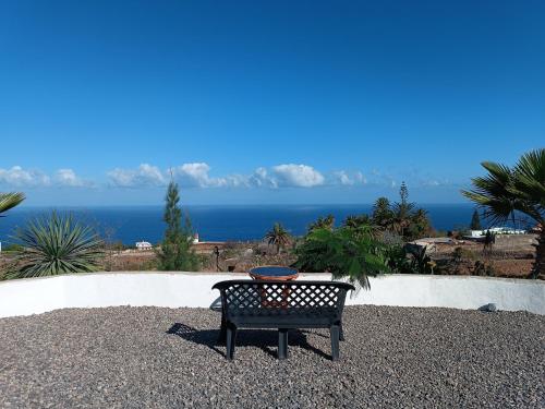 a bench with a bowl on it sitting on top of gravel at Vivaldi Summer in Icod de los Vinos