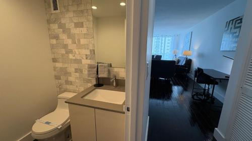 a bathroom with a toilet and a desk in a room at Beachfront 2BR at The Tides | EPIC Stay in Hollywood