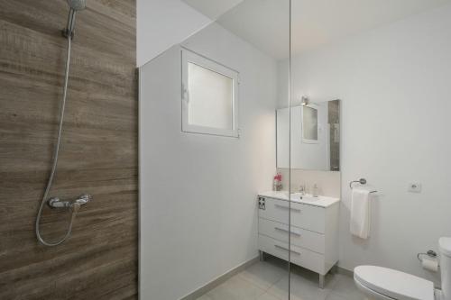 a bathroom with a shower and a sink and a toilet at La Maison Dorée in Porto Santo