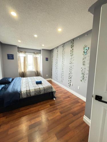 une chambre avec un lit et un parquet dans l'établissement Mississauga Guest House McDowell, à Mississauga