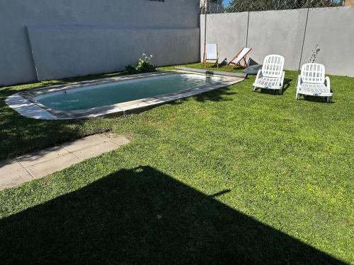 two chairs and a swimming pool in a yard at La Luján Ayres de Campo in Luján