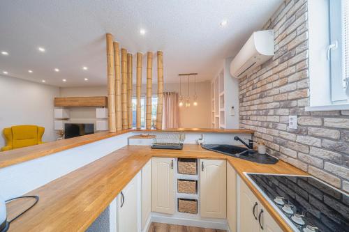 a kitchen with white cabinets and a brick wall at Apartmány Apollo Šírava in Michalovce