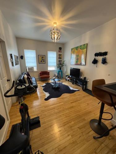 a living room with a hard wood floor and a chandelier at Modern Stay in Downtown Jersey City, Close to NYC! in Jersey City