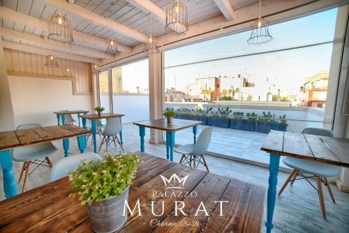 a restaurant with tables and chairs and a large window at Palazzo Murat B&B in Monopoli