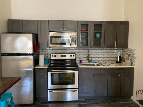 a kitchen with a stove and a refrigerator at Modern Stay in Downtown Jersey City, Close to NYC! in Jersey City