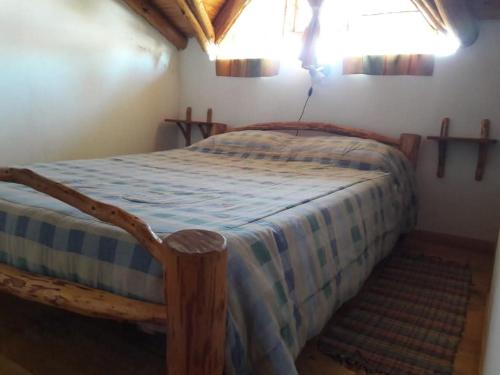 a bedroom with a bed with a blue and white comforter at La Perlita de Trevelin in Trevelin
