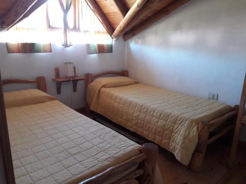 a bedroom with two beds and a window at La Perlita de Trevelin in Trevelín