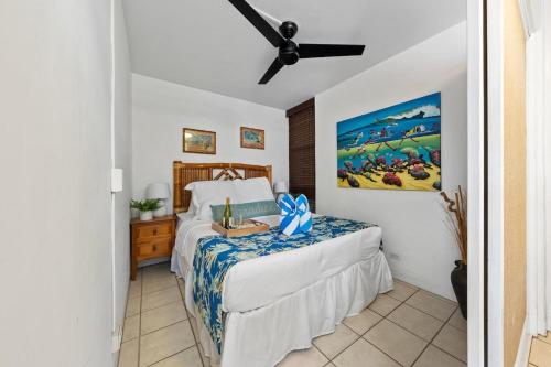 una camera da letto con un letto e un ventilatore a soffitto di Kahana Reef 201 · KR 201 OceanFront 1BD Condo w Ocean Views Pool a Kahana