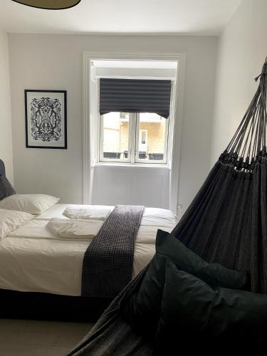 a bed with a hammock in a bedroom with a window at Quiet room in lively area with helpful Host! in Copenhagen