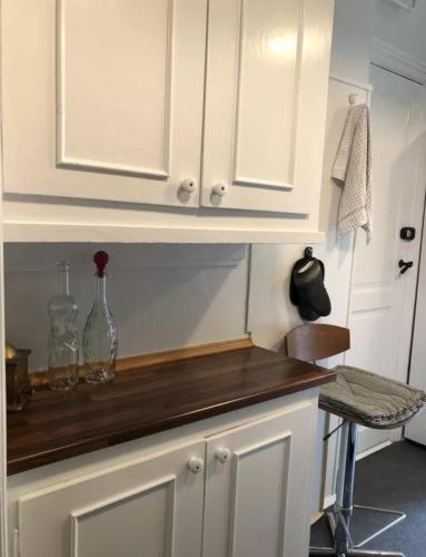 a kitchen with white cabinets and a wooden counter top at Quiet room in lively area with helpful Host! in Copenhagen