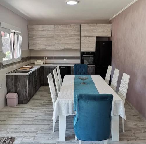 a kitchen with a table and blue chairs in a kitchen at Javahome in Ocho Rios