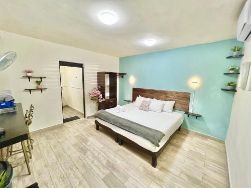 a bedroom with a bed and a blue wall at Habitaciones Bacalar MYD in Bacalar
