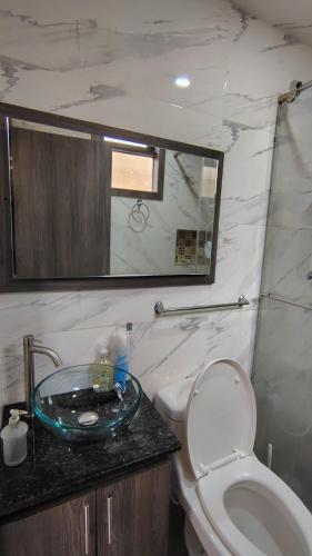a bathroom with a sink and a toilet and a mirror at Apartmento Úbate in Ubaté