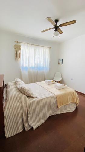 a bedroom with a bed with a ceiling fan at La Laguna Cruz del Eje in Cruz del Eje