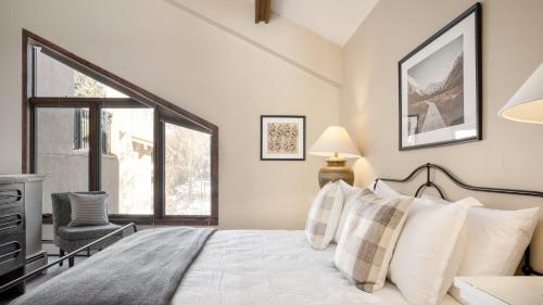 ein Schlafzimmer mit einem Bett und einem Fenster in der Unterkunft Cloud 9 by AvantStay Located at the Base of Vail Ski Resort w Community Pool Hot Tub in Vail
