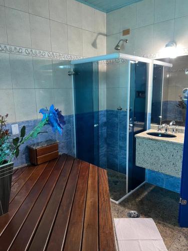 a bathroom with a shower and a sink and a blue shower at Hotel Mooca in São Paulo