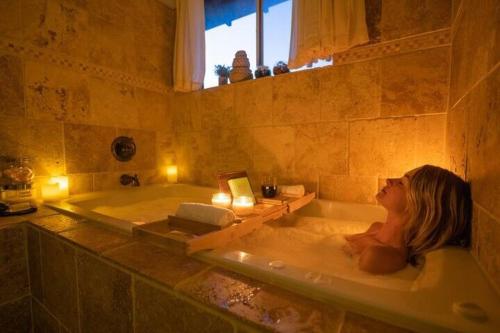 ein kleines Mädchen, das in einer Badewanne in einem Badezimmer liegt in der Unterkunft Hot Tub-Game Room-Nintendo Switch-BBQ in Big Bear City Airport