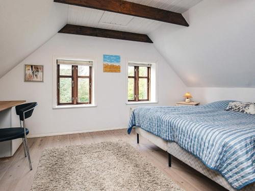 Un dormitorio con una cama y dos ventanas. en 4 star holiday home in Asaa, en Aså