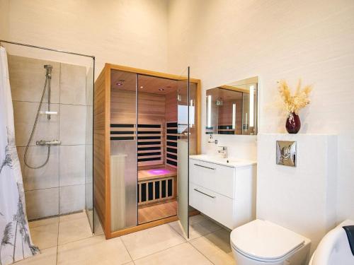 ein Badezimmer mit Dusche, Toilette und Waschbecken in der Unterkunft 5 star holiday home in Løkken in Løkken