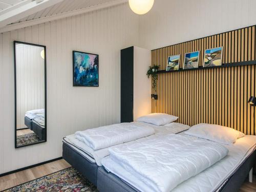 1 cama grande en una habitación con espejo en 4 star holiday home in Silkeborg, en Abildskov