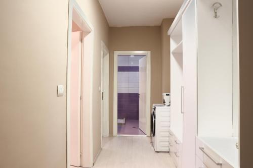 a hallway leading to a bathroom with a sink at Casa Miel en el Botánico in Tirana