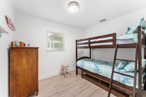 une chambre avec deux lits superposés et une commode dans l'établissement Jupiter Coastal Cottage, à Jupiter