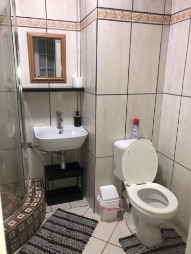 a bathroom with a toilet and a sink at Relaxing Hideaway in Strand