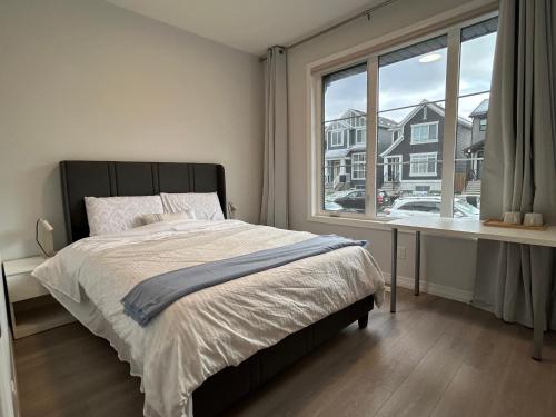 a bedroom with a bed and a large window at Sunny Queen-size Bedroom with Private Bath in Brand New House in Calgary