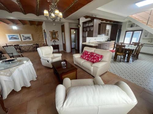 una gran sala de estar con muebles blancos y una cocina. en El Fontanar de Peñarrubia, en Peñarrubia