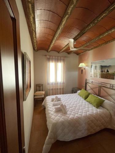 a bedroom with a large bed with a wooden ceiling at El Fontanar de Peñarrubia in Peñarrubia