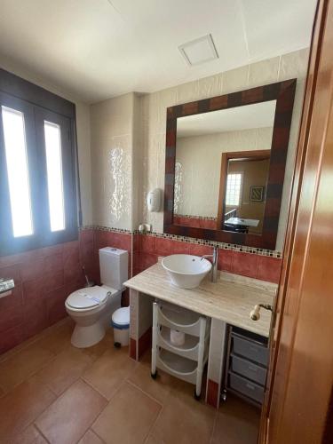 a bathroom with a toilet and a sink and a mirror at El Fontanar de Peñarrubia in Peñarrubia