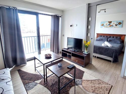 a living room with a bed and a television at Departamento Centro Vista al mar 1D 1B in Antofagasta