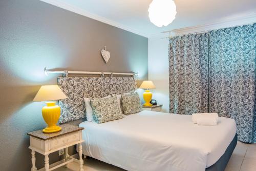 a bedroom with a white bed and two lamps at Casa do Cais in Calheta