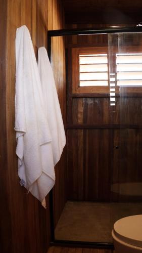 a bathroom with white towels hanging on a wall at Mangal Amaniū in Tatajuba