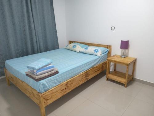 a bedroom with a wooden bed with towels on it at T3 Mindelo in Mindelo
